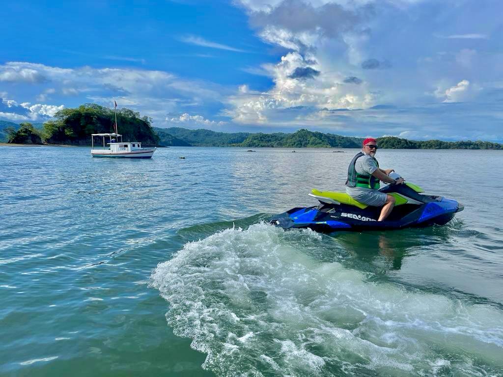 hombre en jet ski con barco de fondo