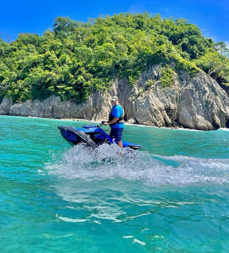 moto acuática frente a una montaña rocosa con vegetación
